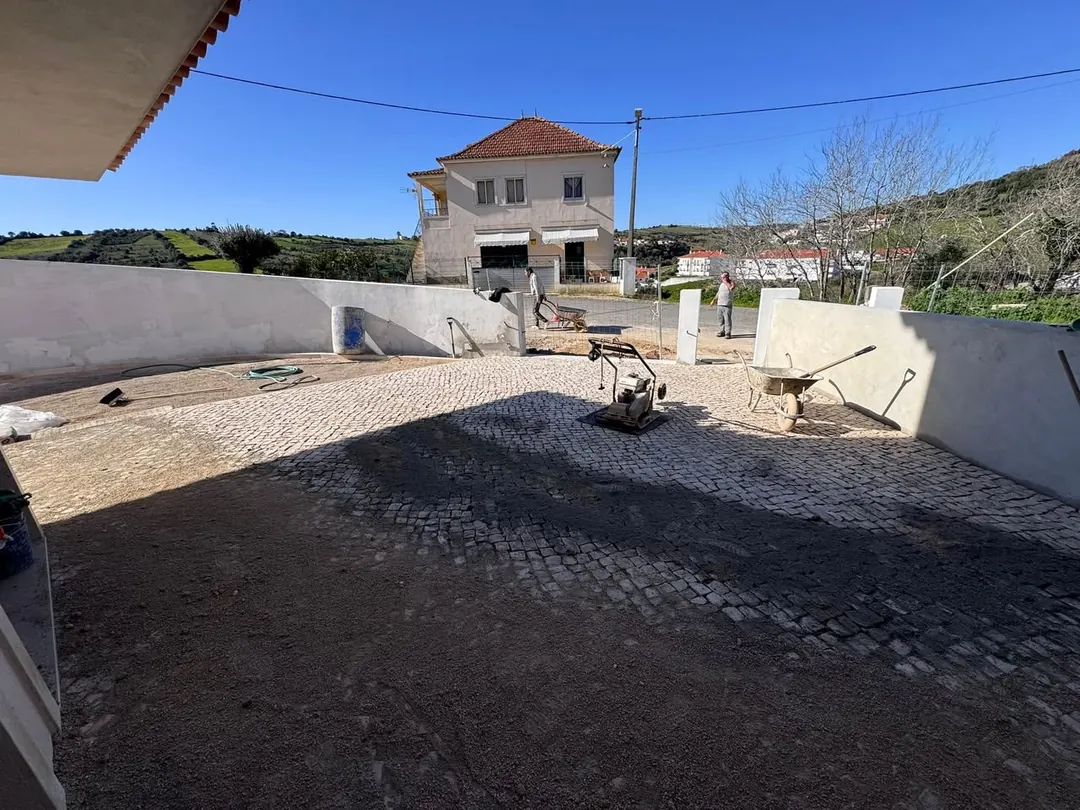 Calçada em pedra em execução num pátio de moradia