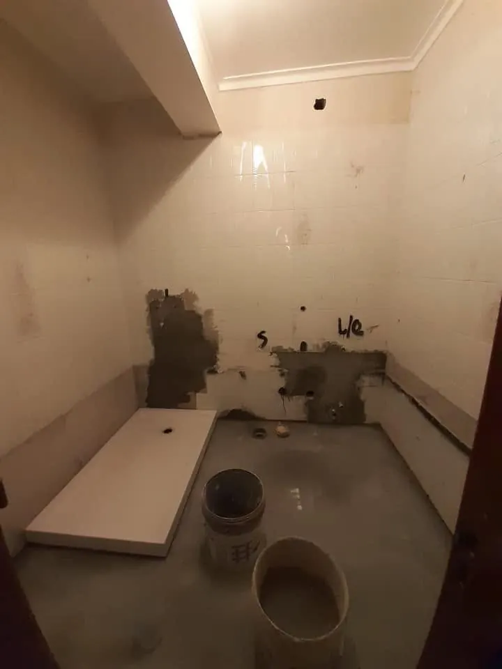 Casa de banho antes da remodelação, sem louças e com paredes picadas
