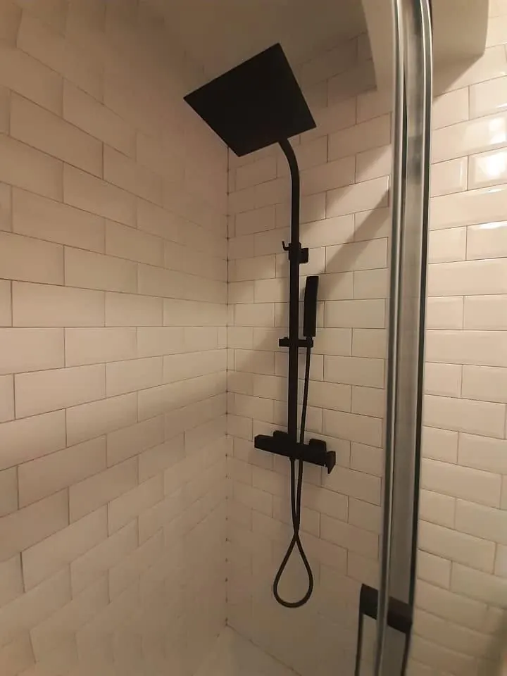Duche com coluna de duche preta e azulejo metro