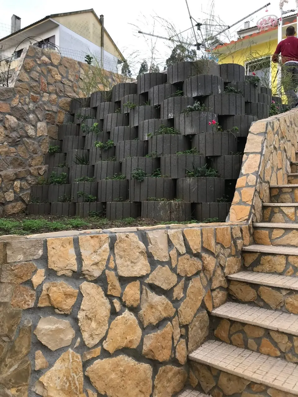 Escadas em pedra junto ao muro de contenção ajardinado